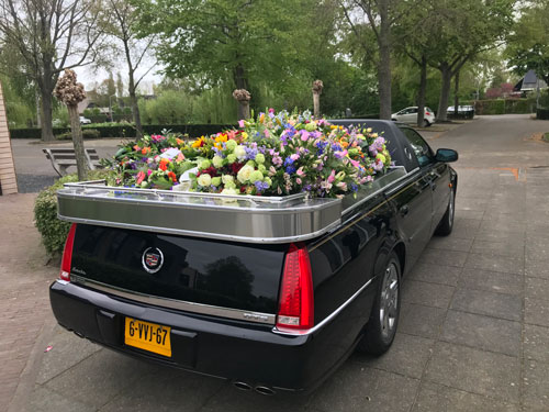 Staatsievervoer Open rouwauto met bloemen
